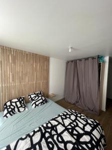 VuillafansにあるAu Petit Casinoの黒と白の枕が付いたベッドのある寝室