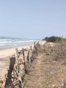 a fence on the side of a beach at Baobab Beach Villa in Abene +2 photos