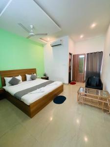 a bedroom with a bed and a chair and a table at Hamlet Beach Villas Alleppey in Alleppey