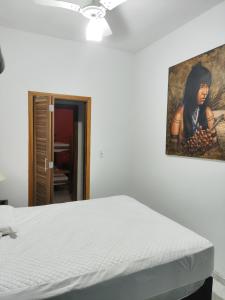 a bedroom with a bed and a painting on the wall at Praia litoral norte SP 70 m praia in Caraguatatuba