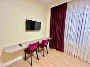 a room with two chairs and a desk with a television at Golden Kent APART&SUİTES in Istanbul