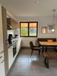 a kitchen with a table and a dining room at Hof Horsten - Wohnidyll in ehemaliger Scheune in Bad Nenndorf