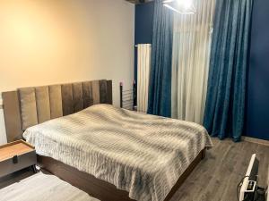 een slaapkamer met een bed met blauwe muren en blauwe gordijnen bij Bakuriani premium comfort in Bakuriani