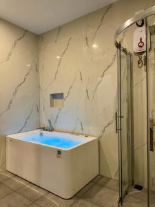 un baño con bañera y ducha en Puerto Paraiso Hostel, en Puerto Princesa