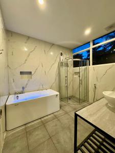 Un baño con bañera blanca y lavabo. en Puerto Paraiso Hostel, en Puerto Princesa