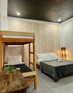 una habitación con dos literas y una mesa en Puerto Paraiso Hostel, en Puerto Princesa