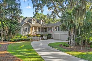 a house with palm trees and a driveway at Cane Current in Hilton Head Island