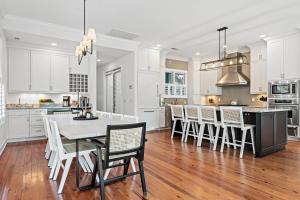 a kitchen with white cabinets and a table and chairs at Cane Current in Hilton Head Island