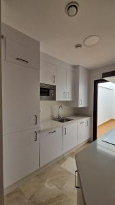 una cucina con mobili bianchi e un lavandino di apartamento Écija Torcal a Écija