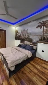 诺伊达Banke bihari farm的卧室里有一张大床，墙上挂着一幅画