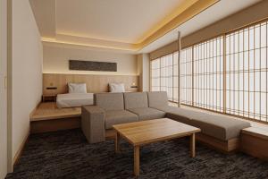 a living room with a couch and a bed at Hotel Fork & Knife Miyajima in Miyajima