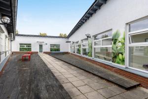 an empty patio of a white building with a red bench at Albrechtshof in Neu Fahrland