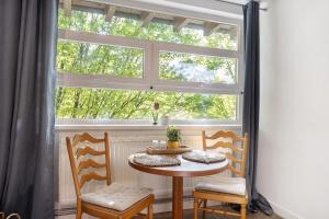 a table and two chairs in front of a window at Albrechtshof in Neu Fahrland