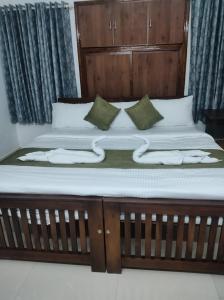 a bed with a wooden headboard and pillows on it at ETERNA Homestay Rackad in Mūvattupula