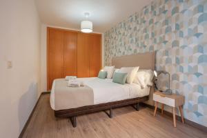 a bedroom with a large bed with blue and gray wallpaper at Obsidian Aregoma La Caleta in Adeje