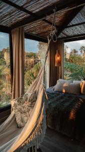 a hammock bed in a room with a large window at Element Quindío in Boquía