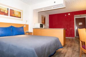 ein Schlafzimmer mit einem großen Bett und eine Küche in der Unterkunft Hotel Galerías Express in Tepatitlán