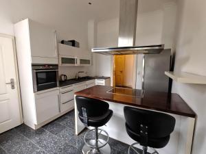 une cuisine avec un comptoir et deux tabourets de bar dans l'établissement Schiefe Stadtvilla Oldenburg - großes Altbauhaus, à Oldenbourg