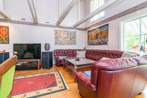 a living room with leather couches and a flat screen tv at VGO822-Fjaeras-Grimmeredsvaegen-35 in Ubbhult