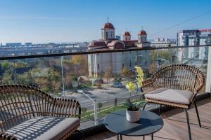 un balcon avec deux chaises et une table avec vue dans l'établissement Luxurious apartment by Hotel Casa David 2025, à Craiova