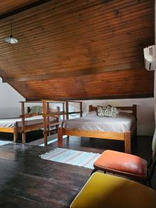 a bedroom with two beds and a wooden ceiling at Chalés boiçucanga in Boicucanga