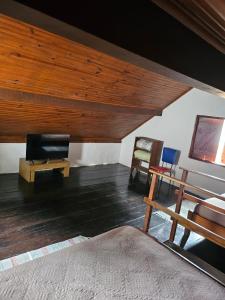 a living room with a bed and a wooden ceiling at Chalés boiçucanga in Boicucanga