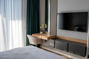 une chambre d'hôtel avec un lit et une télévision dans l'établissement Luxurious apartment by Hotel Casa David 2025, à Craiova