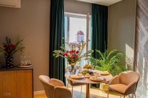 une salle à manger avec une table et des chaises et une fenêtre dans l'établissement Luxurious apartment by Hotel Casa David 2025, à Craiova