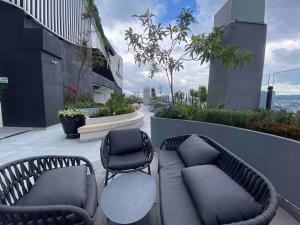 キトにあるSuite Piso 17 - Increible Vista - Agua filtrada ilimitadaの建物の屋上には椅子2脚とソファが置かれている