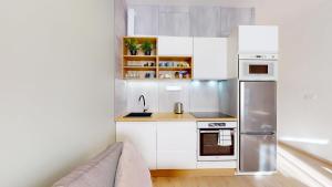 a kitchen with white cabinets and a stainless steel refrigerator at 3unity Apartment Kamence in Kysucké Nové Mesto