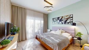 a bedroom with a bed and a desk and a television at 3unity Apartment Kamence in Kysucké Nové Mesto