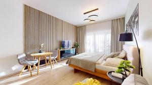 a bedroom with a bed and a table and chairs at 3unity Apartment Kamence in Kysucké Nové Mesto