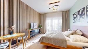 a bedroom with a bed and a table and a tv at 3unity Apartment Kamence in Kysucké Nové Mesto