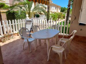 een tafel en stoelen met een blauwe tafel en een hek bij Manuel 217 en Gran Alacant in Gran Alacant