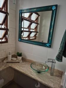a bathroom with a glass sink and a mirror at Praia litoral norte SP 70 m praia in Caraguatatuba +39 photos