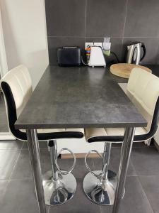 ein Tisch mit weißen Stühlen und einer Theke in der Unterkunft Appartement Vue mer La Croix Valmer in La Croix-Valmer + 2 Fotos
