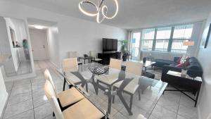 ein Esszimmer und ein Wohnzimmer mit Tisch und Stühlen in der Unterkunft Sea Air Towers - Oceanfront Condo w Pool & Gym in Beverley Beach