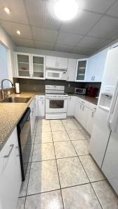 eine Küche mit weißen Schränken und weißen Geräten in der Unterkunft Sea Air Towers - Oceanfront Condo w Pool & Gym in Beverley Beach