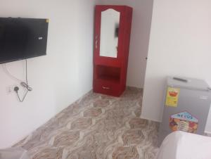 a room with a red door and a television at Eastern Comfort Hotel in Koforidua