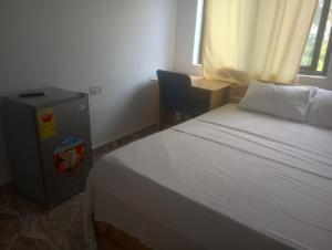 a bedroom with a bed and a desk and a chair at Eastern Comfort Hotel in Koforidua