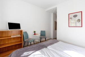 a bedroom with a bed and two chairs and a tv at Albrechtshof in Neu Fahrland