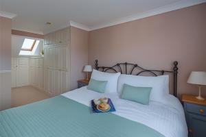 a bed with a blue tray with a hat on it at Little Chequers in Friston