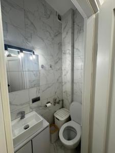 un bagno bianco con un water e un lavandino di Квартира a Dnipro