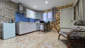 a kitchen with a refrigerator and a couch in a room at Shahal Apartments in Beer Sheva