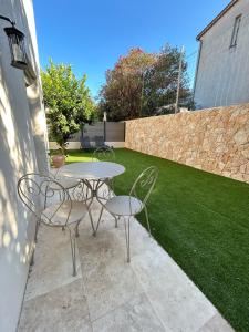 a patio with two chairs and a table and a lawn at St Paul de Vence in Cagnes-sur-Mer