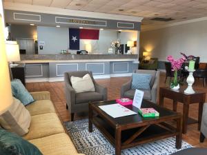 a living room with couches and a coffee table at The Grand Hotel Spindletop in Beaumont