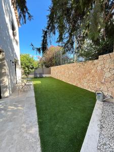 a garden with a stone wall and green grass at St Paul de Vence in Cagnes-sur-Mer +42 photos