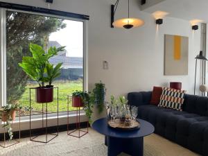 Una sala de estar con un sofá y una mesa con plantas. en Villa de rêve - Sauna - Spa - babyfoot - Arcade, en Quatzenheim