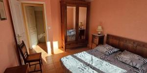 サント・クロワ・デュ・ヴェルドンにあるL'amourié, Rdc, Gîte 4 Personnesのベッドルーム1室(ベッド1台、椅子、鏡付)