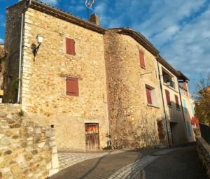 サント・クロワ・デュ・ヴェルドンにあるL'amourié, Rdc, Gîte 4 Personnesの赤いシャッターが付いた古い石造りの建物